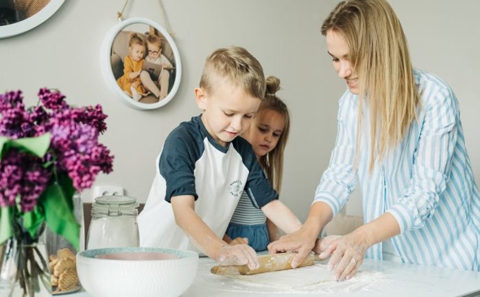 Mother and children enjoying a fun and messy baking session together at home.