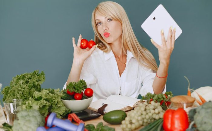 Vlogger promoting healthy eating with fresh vegetables on the table.